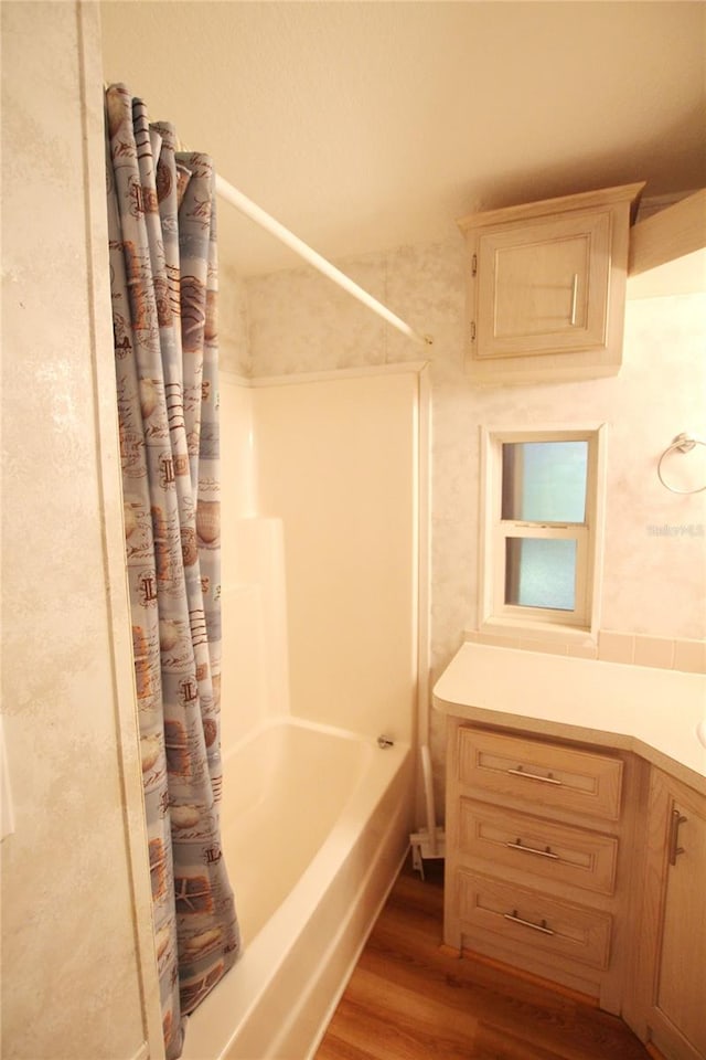 bathroom featuring hardwood / wood-style floors, vanity, and shower / tub combo with curtain