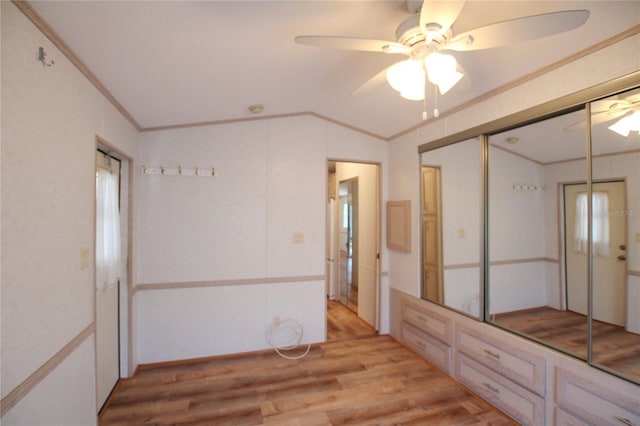 empty room featuring light hardwood / wood-style floors, ceiling fan, and vaulted ceiling