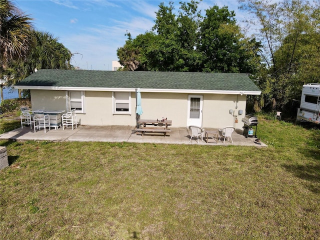 back of property with a patio area and a yard