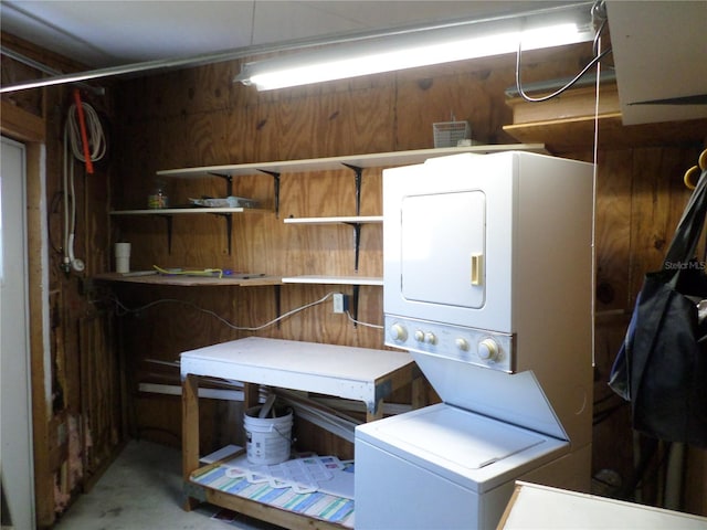 laundry room with wood walls and stacked washing maching and dryer