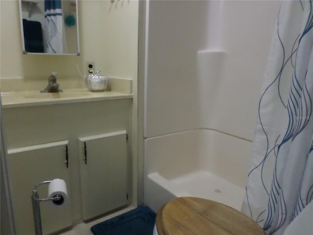 bathroom with walk in shower, toilet, and vanity