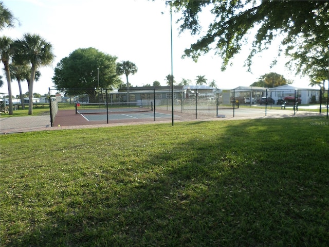 view of sport court featuring a lawn