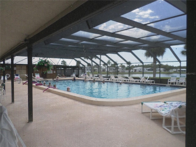 view of swimming pool featuring a lanai and a patio area