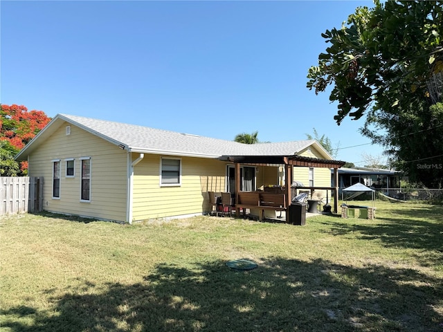 rear view of property with a yard