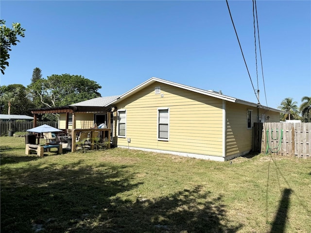 back of property featuring a pergola and a yard