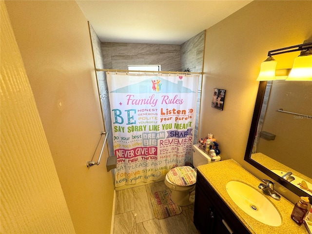 bathroom with vanity, toilet, and curtained shower