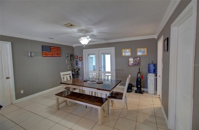 dining space featuring ornamental molding, light tile patterned floors, a textured ceiling, and french doors