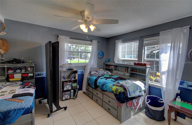 tiled bedroom featuring ceiling fan and a textured ceiling