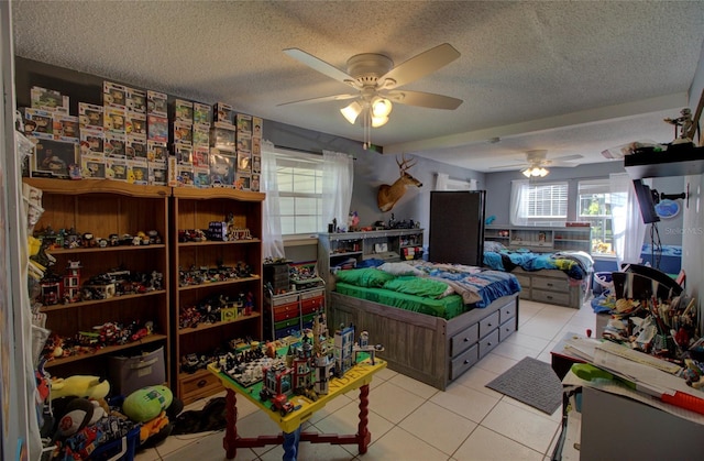 tiled bedroom with multiple windows, ceiling fan, and a textured ceiling