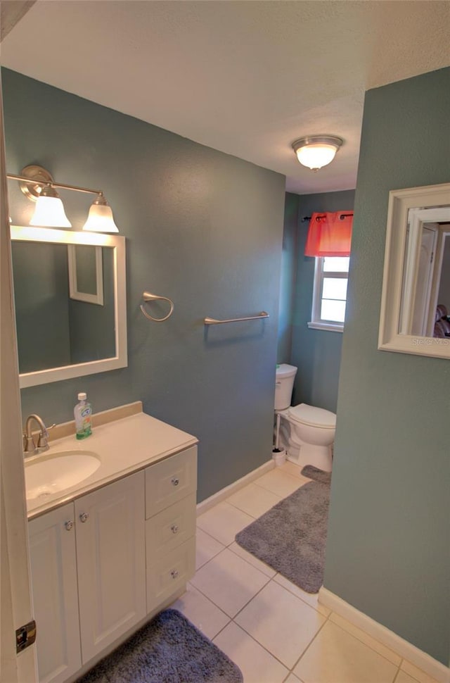 bathroom featuring tile patterned flooring, vanity, and toilet