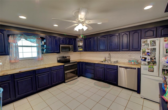 kitchen featuring blue cabinets, appliances with stainless steel finishes, sink, and backsplash