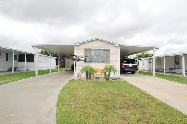 manufactured / mobile home with a carport and a front yard