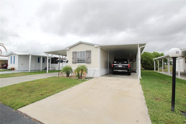 manufactured / mobile home with a front yard and a carport