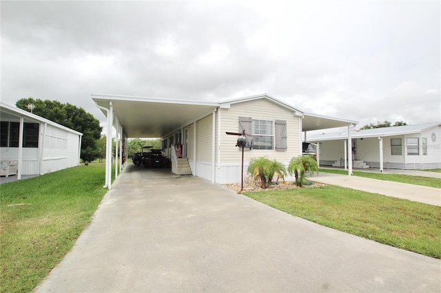 manufactured / mobile home with a front yard and a carport