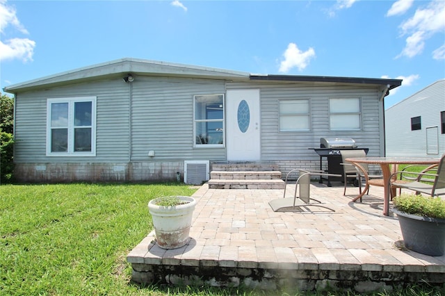 back of property featuring a patio and a yard