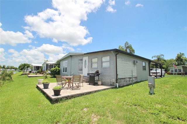 back of property featuring a patio area and a yard