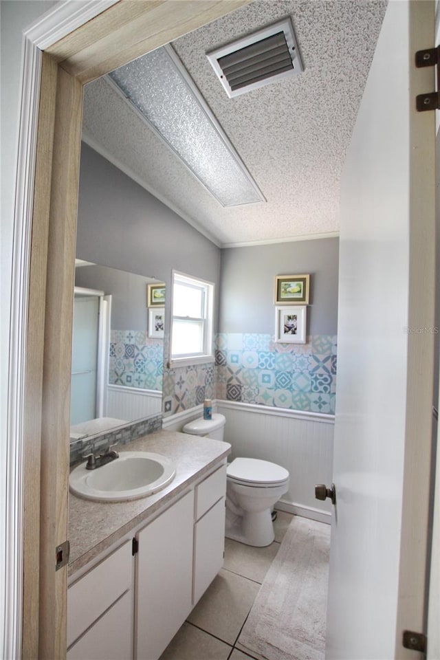 bathroom with vanity, tile patterned flooring, toilet, and a textured ceiling