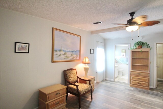 living area featuring a textured ceiling, ceiling fan, and light tile patterned floors