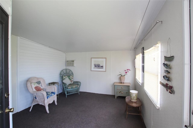 sitting room featuring carpet floors and a wall unit AC