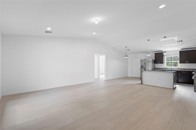 interior space featuring sink, lofted ceiling, and light hardwood / wood-style floors