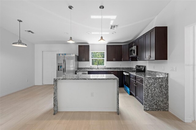 kitchen featuring stainless steel appliances, pendant lighting, a center island, light stone countertops, and light hardwood / wood-style flooring