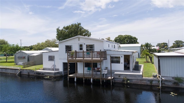 back of property featuring a lawn, a patio area, and a deck with water view