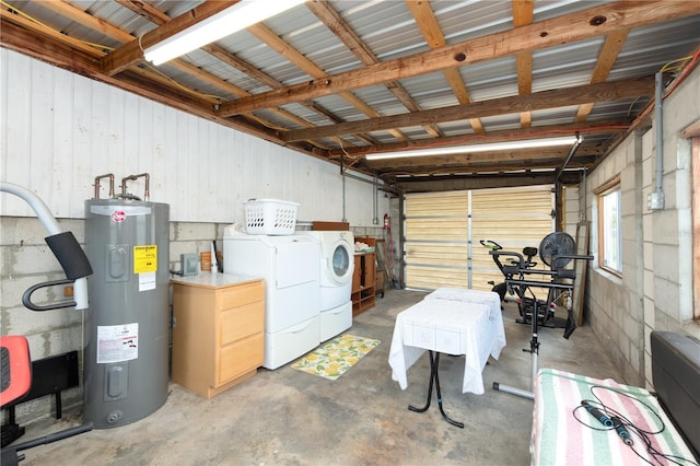 garage with electric water heater and washer and clothes dryer