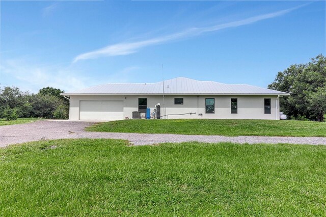 single story home featuring a front yard, cooling unit, and a garage