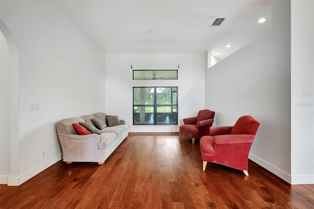 living area with high vaulted ceiling and dark hardwood / wood-style flooring