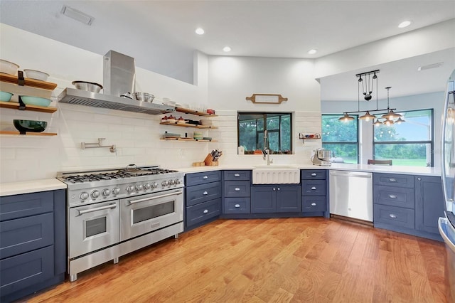 kitchen with light hardwood / wood-style floors, tasteful backsplash, sink, exhaust hood, and appliances with stainless steel finishes