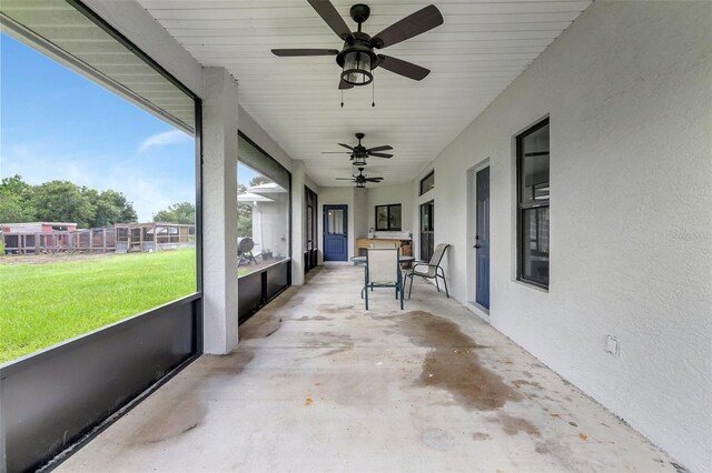 unfurnished sunroom featuring wood ceiling and ceiling fan