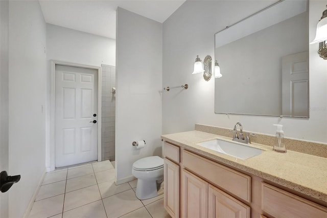 bathroom with tiled shower, tile patterned flooring, vanity, and toilet