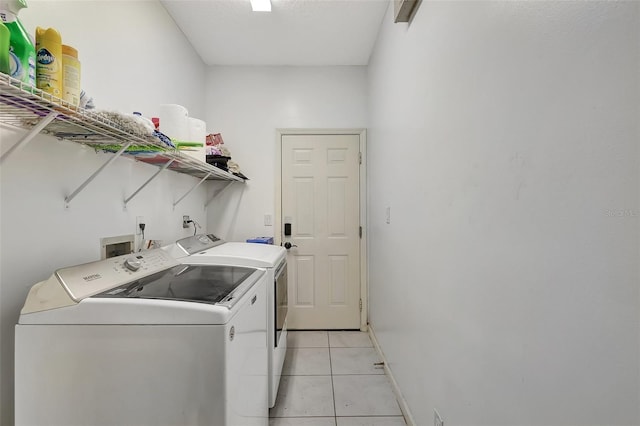 laundry area featuring light tile patterned floors and separate washer and dryer