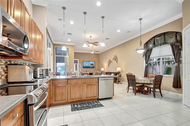 kitchen with light tile patterned flooring, ceiling fan, appliances with stainless steel finishes, pendant lighting, and sink