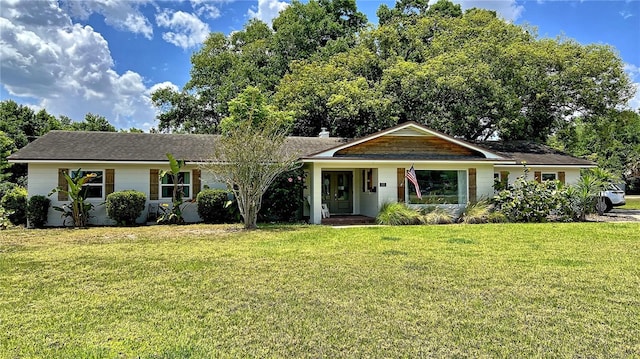 ranch-style house featuring covered porch and a front lawn