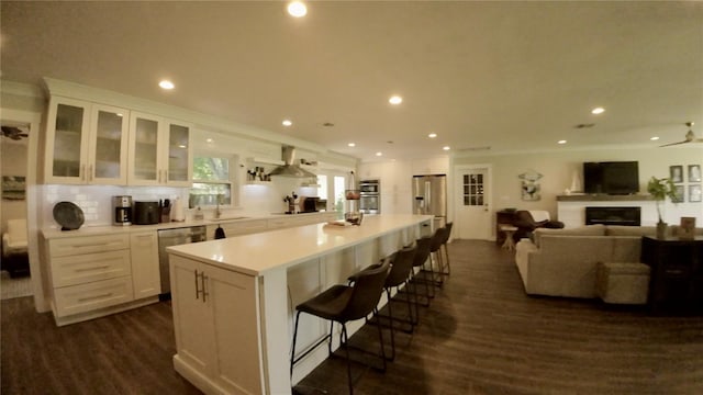 245 Lake Seminary Cir, Maitland, FL 32751 - kitchen featuring dark wood-style floors, white cabinets, appliances with stainless steel finishes, wall chimney range hood, and open floor plan