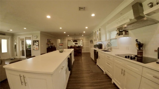 kitchen featuring crown molding, a kitchen island, sink, dark hardwood / wood-style floors, and black electric cooktop