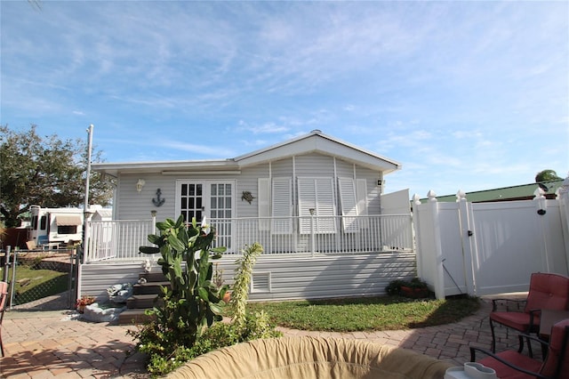 view of front of property featuring a gate, a patio, and fence