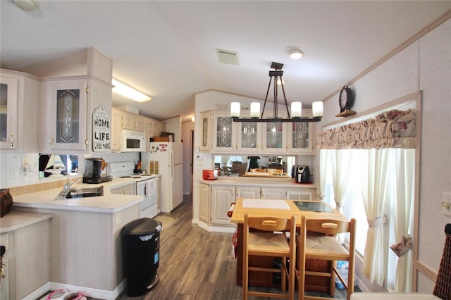 kitchen with pendant lighting, lofted ceiling, light countertops, glass insert cabinets, and white appliances