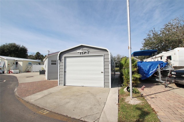 detached garage featuring concrete driveway