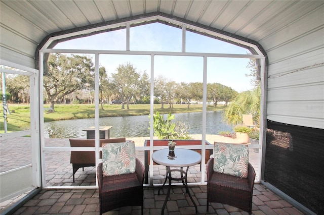 sunroom / solarium featuring a water view and vaulted ceiling