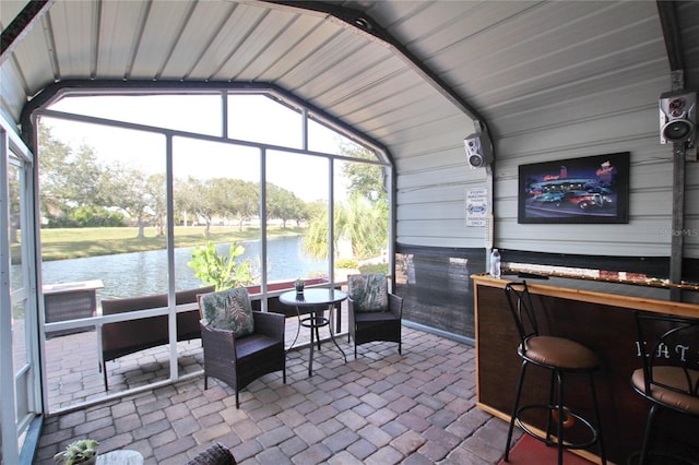 sunroom with a water view and lofted ceiling