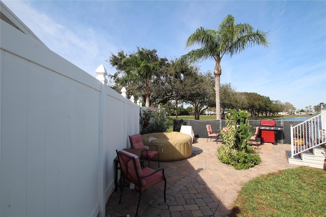 view of patio with a hot tub and a fenced backyard