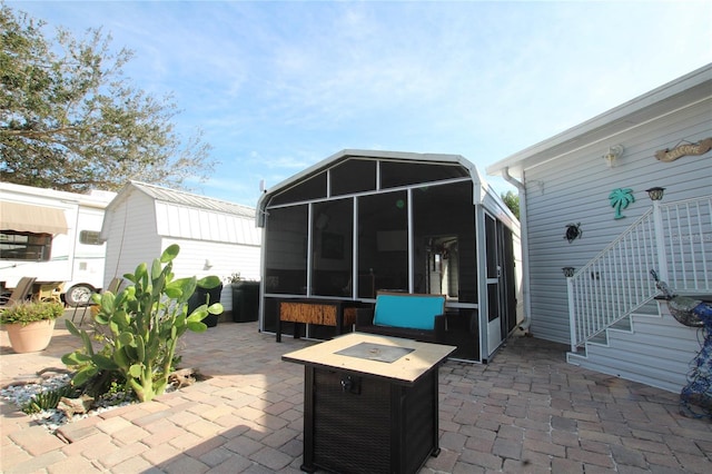 view of patio / terrace with a sunroom and a fire pit