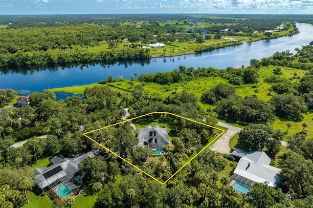 birds eye view of property featuring a forest view and a water view