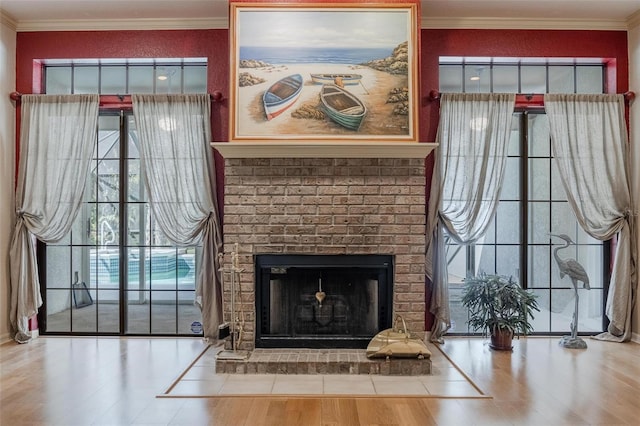 unfurnished living room featuring brick wall, wood-type flooring, ornamental molding, and a brick fireplace