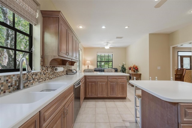 kitchen featuring kitchen peninsula, sink, decorative backsplash, ceiling fan, and light tile patterned flooring