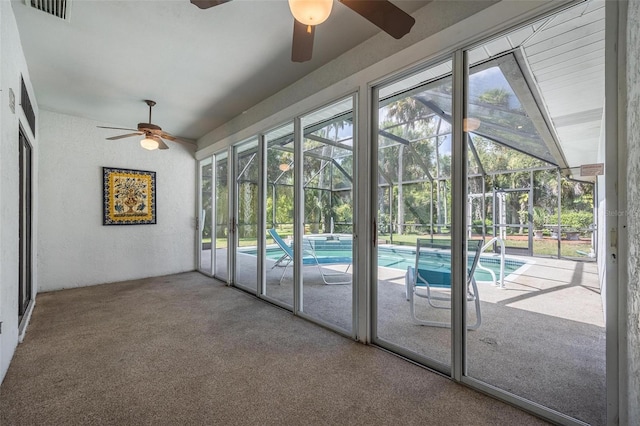 unfurnished sunroom featuring ceiling fan, a wealth of natural light, and vaulted ceiling