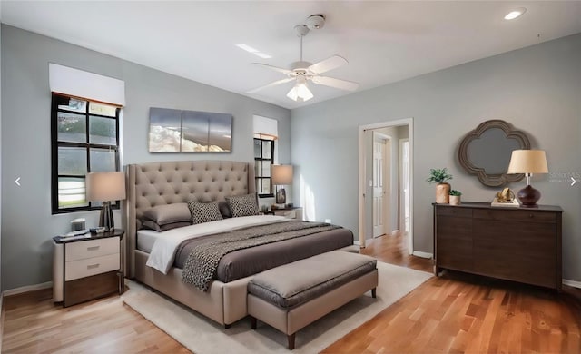 bedroom with light wood-style floors, baseboards, and ceiling fan