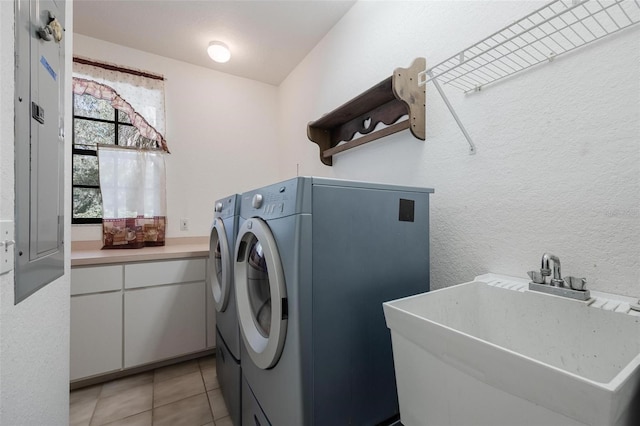 laundry room featuring independent washer and dryer, sink, and light tile patterned floors